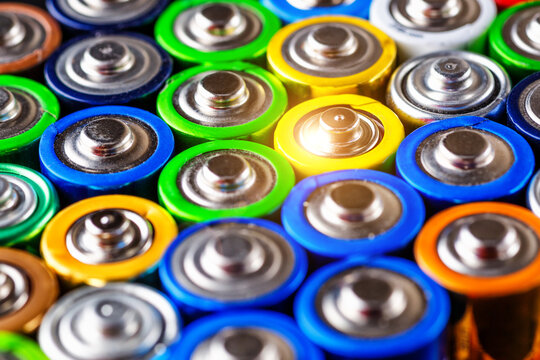 Energy abstract background of colorful batteries.Used batteries from different manufacturers, waste, collection and recycling,Alkaline battery aa size.Concept background of colorful batteries