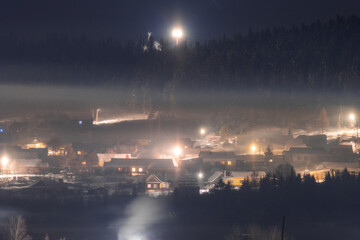 Naklejka na ściany i meble view of the settlement at frosty winter night with fog and haze in Permsky kray, Russia