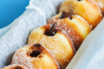 Homemade fried doughnuts with sugar and chocolate filling. Close up.