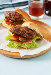 Homemade burgers on a wooden plate. Close up.