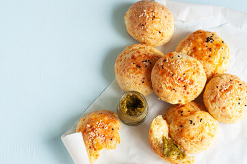 Homemade small cheese dinner rolls with sesame seeds on a baking paper.