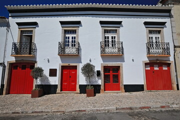 Whitewashed facade-vernacular townhouse-red doors-four balconies with wrought iron railings. Tavira-Portugal-069 - obrazy, fototapety, plakaty