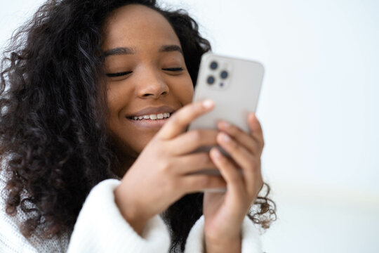 African American Girl Using  Smartphone Pressing Finger, Reading Social Media Internet, Typing Text Or Shopping Online Mobile Phone In Two Black Hands 