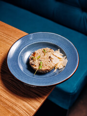 Risotto with porcini mushroom and parmesan cheese on blue plate