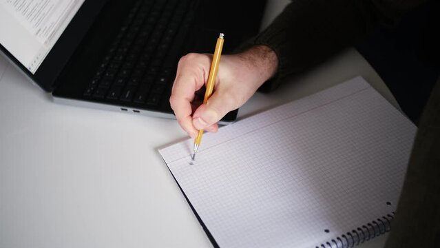  Caucasian Male Procrastinating Drawing Abstract Shapes in Square Ruled Notebook with Mechanical Pencil during Boring Meeting