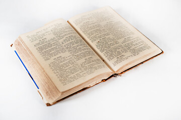 Obraz premium 100 years old holy bible book on white background framed from side with open pages and visible text
