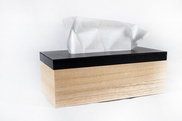 wooden box of paper towels with black cover on white background with visible tissue