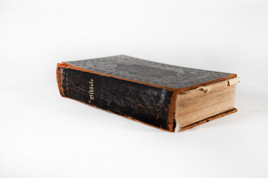 100 years old retro holy bible book with hard covers and dark color on white background