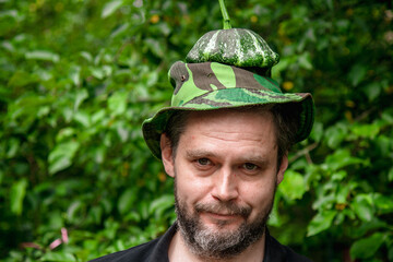 Portrait of a farmer man with a mature juicy pattison on his head	

