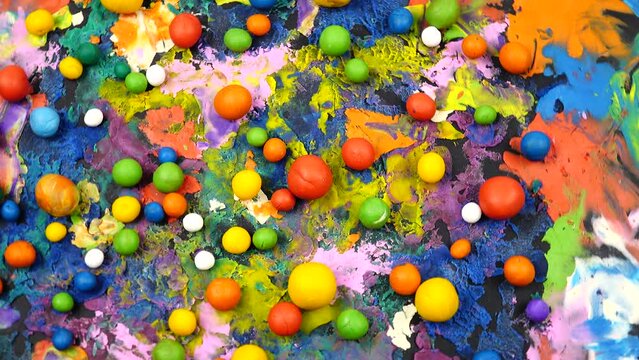 Multi colored plasticine balls and cardboard with plasticine abstract painting rotate on a photography turntable