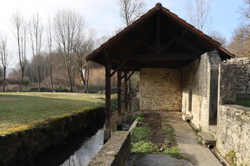Fototapeta na wymiar Ancien lavoir en pierre au bord de la rivière, village de Morestel, département de l'Isère, France
