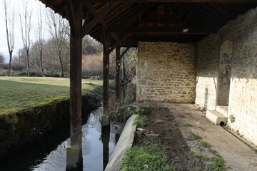 Ancien lavoir en pierre au bord de la rivière, village de Morestel, département de l'Isère, France
