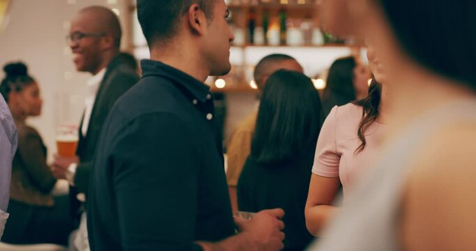 Tonight is all about making new friendships. Diverse group young people having drinks and socialising at a party. Social crowd standing and chatting during the night at a club, bar or restaurant