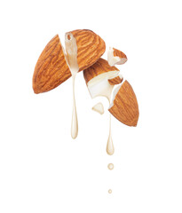 Milk drops dripping from broken almonds close-up on white background