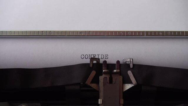 Typing word CONFIDENTIAL on retro typewriter. Close