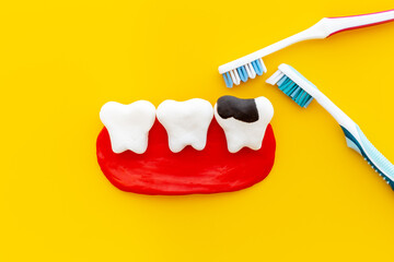 Teeth models with caries or plaque and toothbrush. Oral health concept