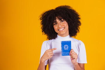 Young afro woman holding a Brazilian work card. Labor reform, fgts, salary and formal worker concept