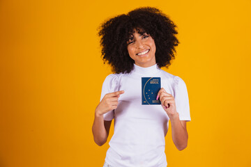 afro woman holding a brazilian passport in hands.