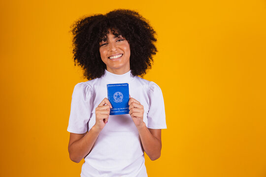 Young afro woman holding a Brazilian work card. Labor reform, fgts, salary and formal worker concept