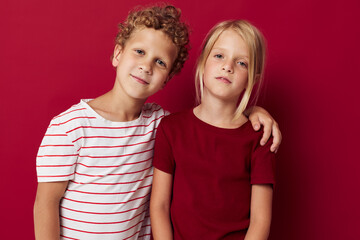 Portrait of cute children good mood standing next to posing on colored background