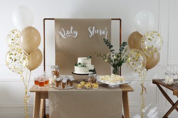 Beautiful cake and other treats on table in room. Baby shower party
