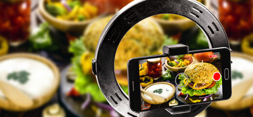 mobile device filming video of hamburger, snack image being recorded in high resolution for food delivery app