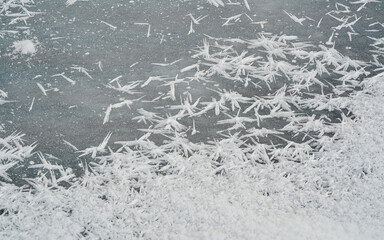 Ice crystals forming spike shapes on frozen river, closeup macro detail