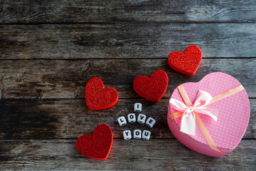 Fototapeta premium Pink Valentine's Day gift box on wooden table with I Love You text and copy space