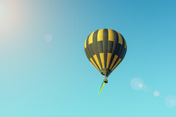 Multicolored hot air balloon with the flag of Ukraine on a blue sky background
