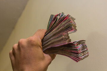 Hand holding stacks of Sudanese Pound banknotes
