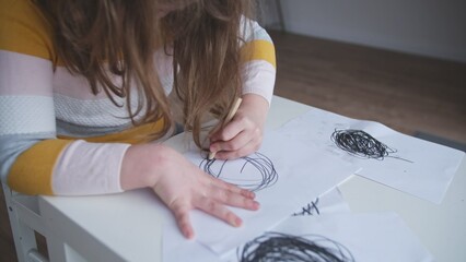 Young Troubled Caucasian Kid Child Girl Drawing Disturbing Chaotic Black Shapes and Circles on...