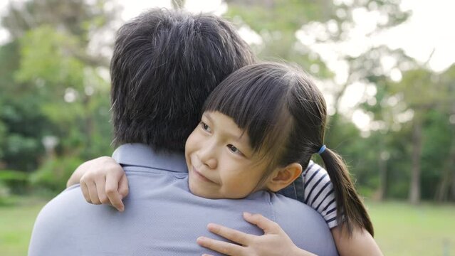 Portrait of fun family daddy and daughter in the park. Beautiful child embraces father. Portrait of happy little asian girl. Education care, happy Father's Day close up outdoor concept.