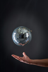 A disco ball levitating above a man's hand, old school party concept