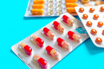 blisters of red and orange pills on a blue background
