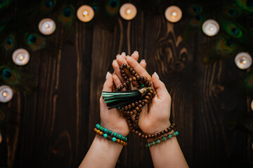 Woman holds in hand wooden mala beads strands used for keeping count during mantra meditations....