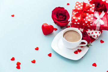 White cup of coffee with gift and roses. morning breakfast. Holiday background. Greeting card. Valentines Womans Mothers day. Top view. Flat lay