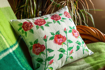 Decorative pillow with embroidery in the form of roses.