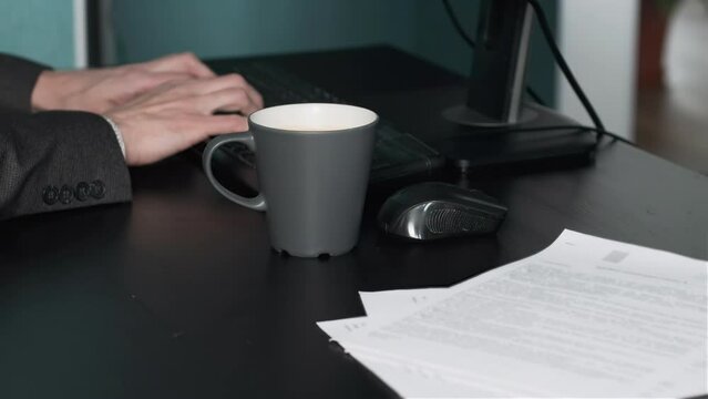 Man Accidentally Spilling Coffee on his Desk while Working. Slow Motion. Business and Lifestyle Concept