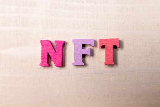 nft letters on light wooden background