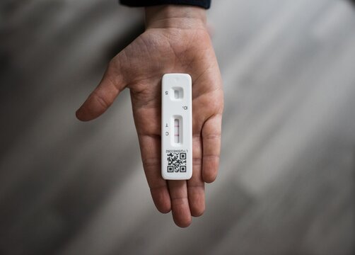 child's hand holding positive lateral flow COVID test