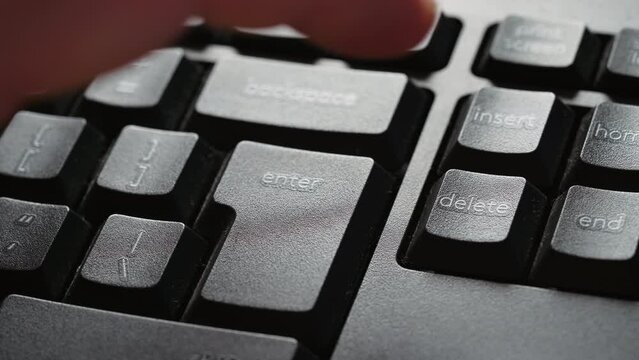 Hitting the enter key or delete key on computer keyboard. Fingers pressing on enter or delete option from PC.Extreme closeup keyboard.