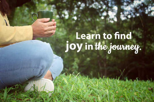 Inspirational quote - Learn to find joy in the journey. With relax legs of a woman sitting alone in the park with coffee or tea cup in hand. Love life and the process concept.