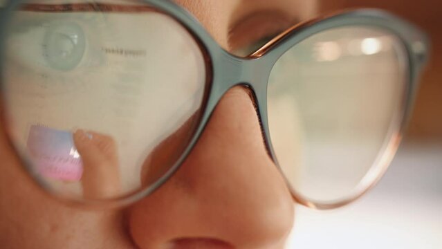 Reflection in glasses of the female hands and credit card making e bank online payment. Woman consumer paying for purchase in web store using laptop technology. Ecommerce website payments concept.