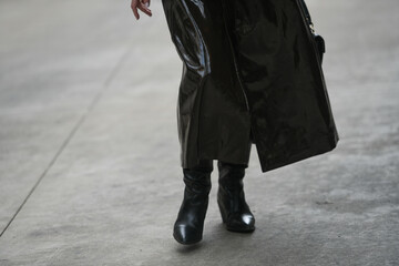 woman wearing shiny black coat and leather shoes