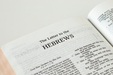 Hebrews Bible Book isolated on white background. A closeup. New Testament Scripture. Studying the gospel of God Jesus Christ. Christian biblical concept of love, faith, trust. - obrazy, fototapety, plakaty