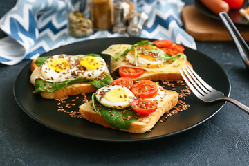 Plate with tasty toasts on dark background