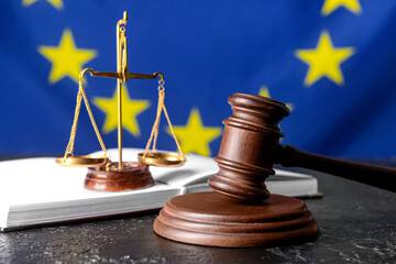 Gavel of judge with scales of justice and book against European Union flag