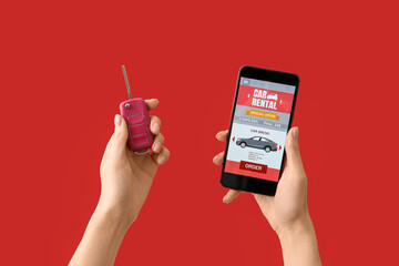 Woman holding mobile phone with open car rent app and key on red background