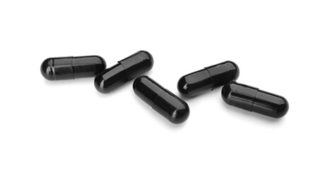 Activated carbon in capsules on white background