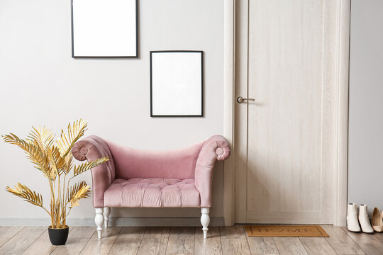 Interior Of Light Hall With Armchair, Frames And Wooden Door